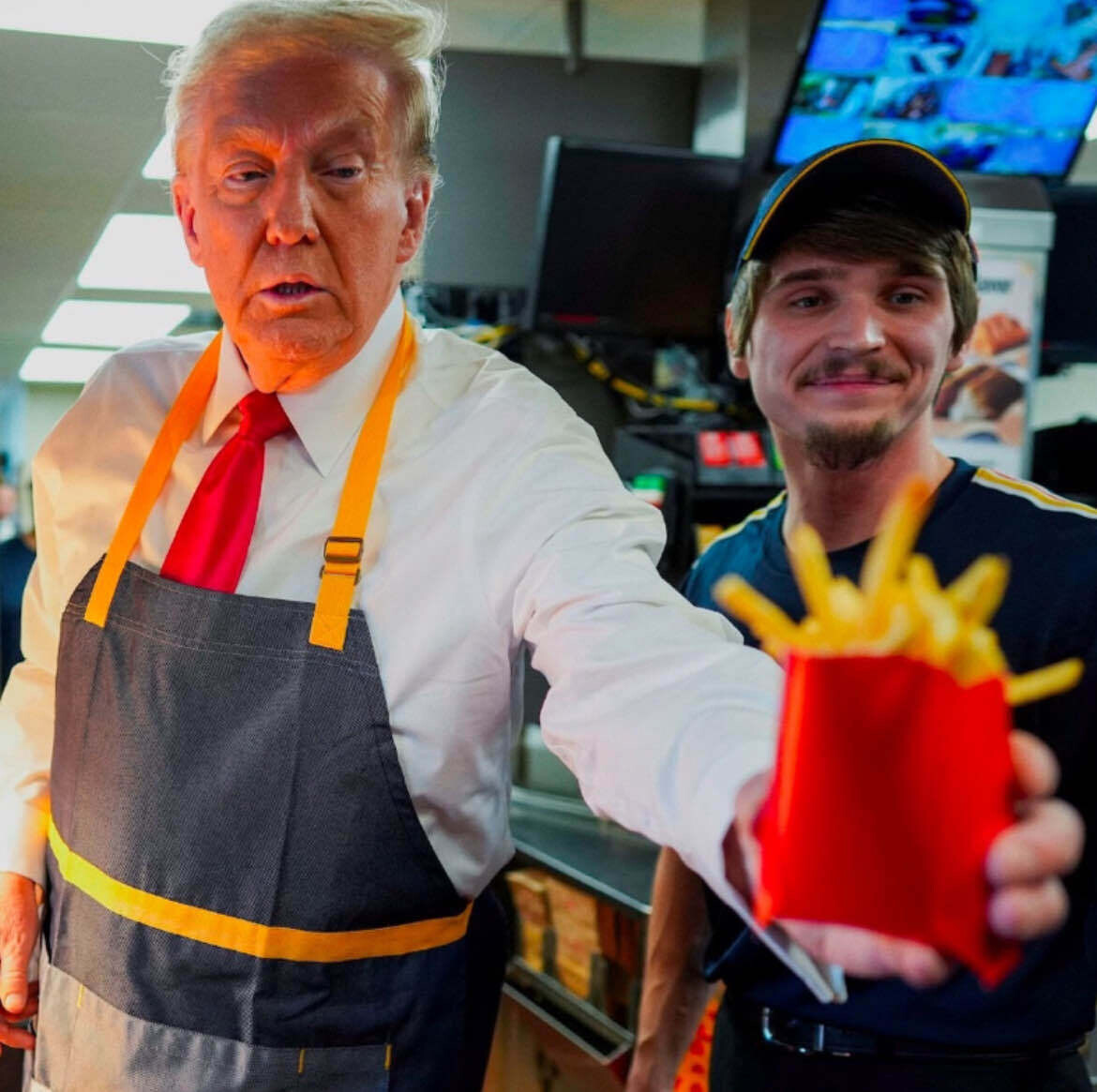 A sickly, old man serving French fries in a staged photo op in a closed